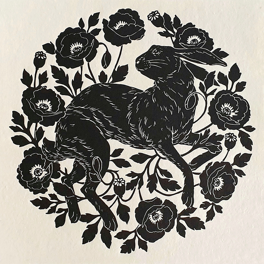 Linocut print of a black hare and poppies on white paper