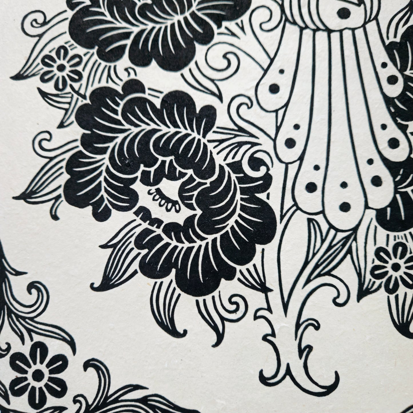 Detail of a black floral linocut print on white paper