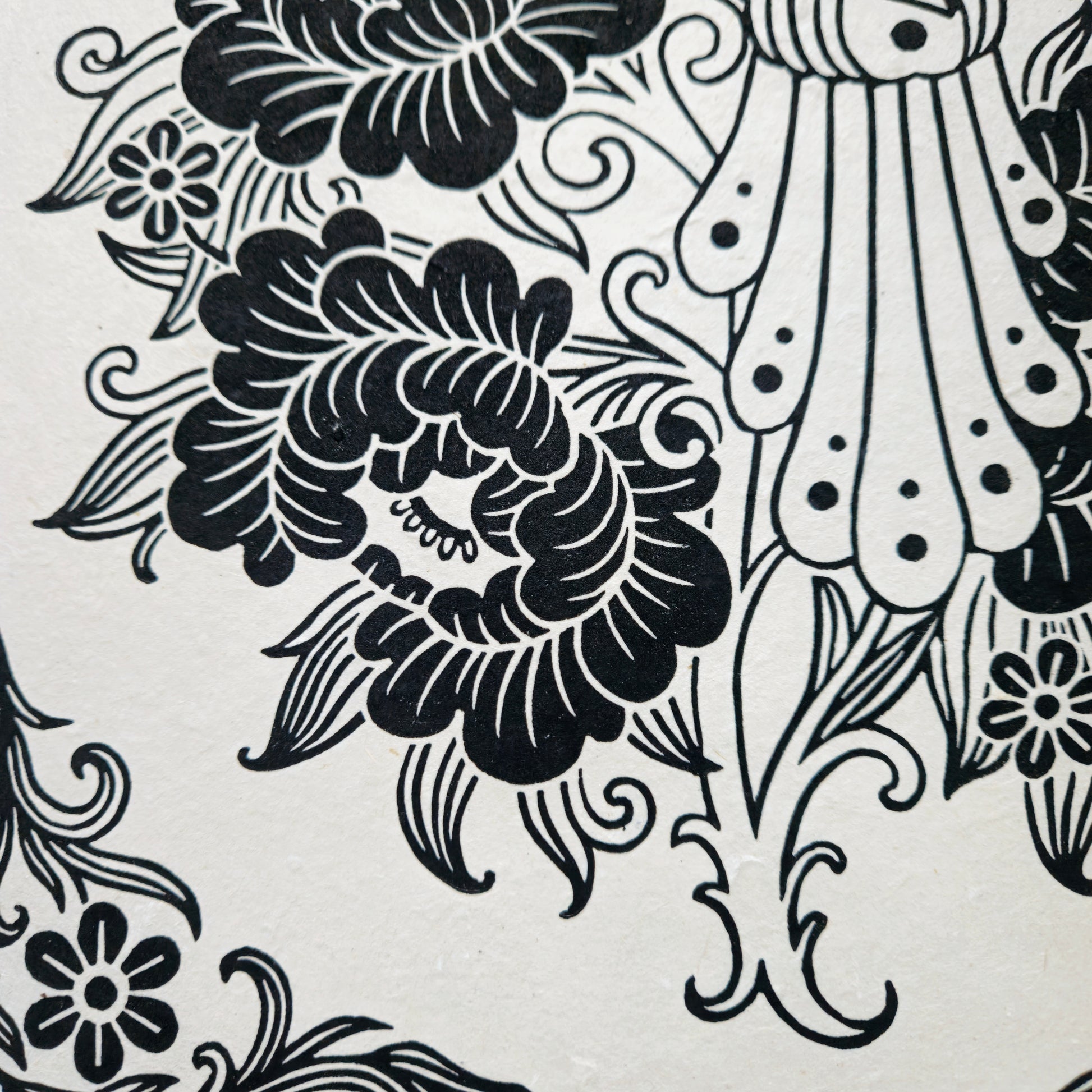 Detail of a black floral linocut print on white paper
