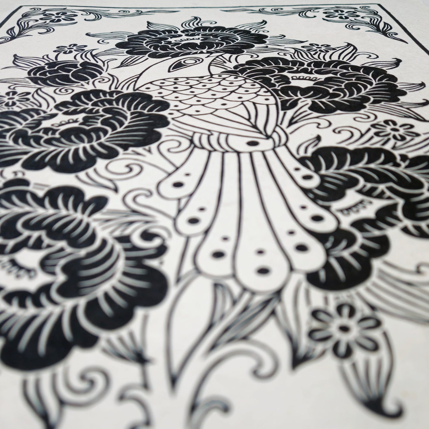 Side view of a black floral linocut print on white paper