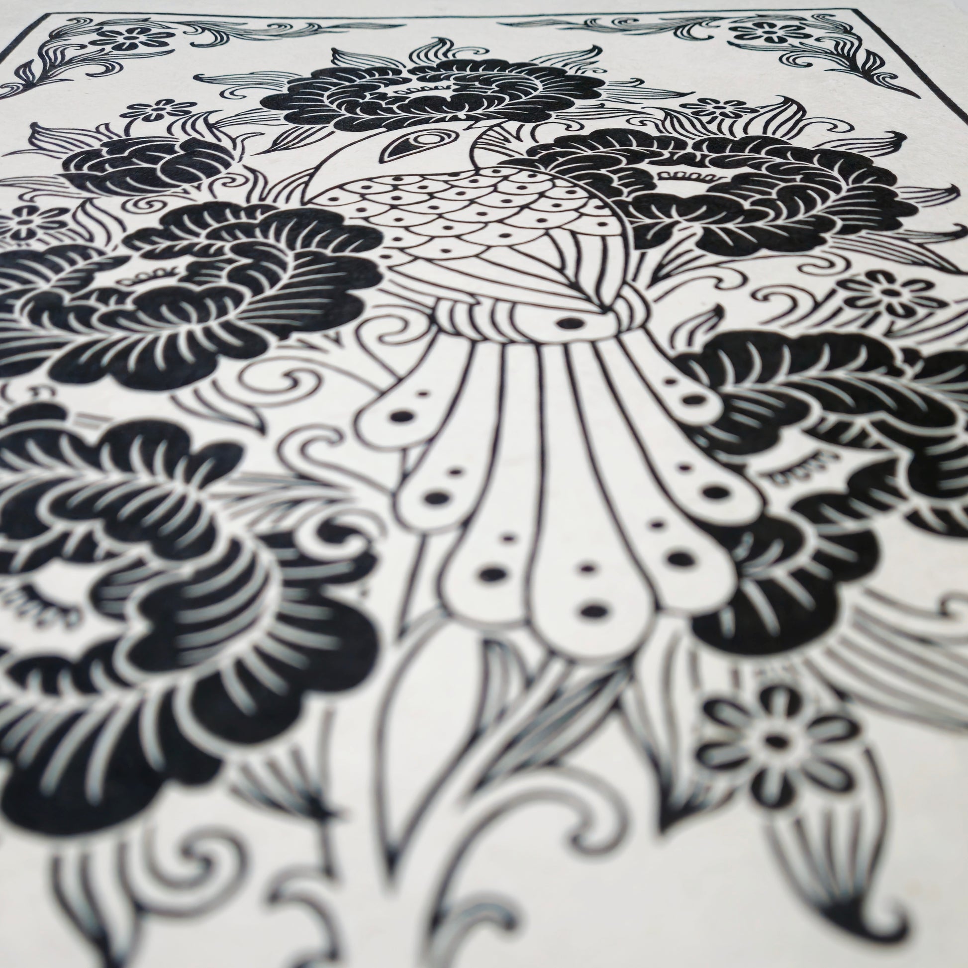 Side view of a black floral linocut print on white paper