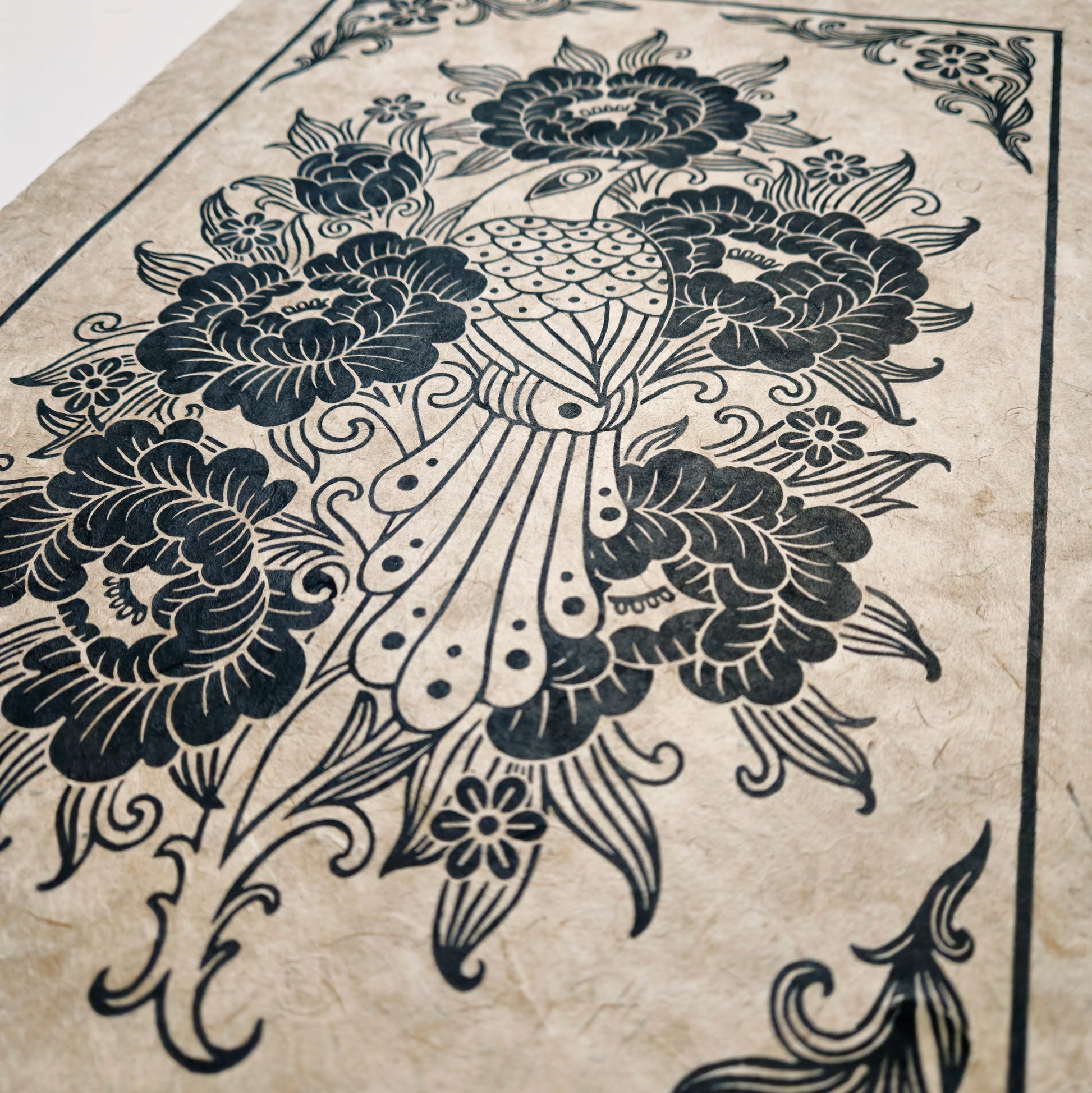 Side view of linocut print with bird and flowers on unbleached paper