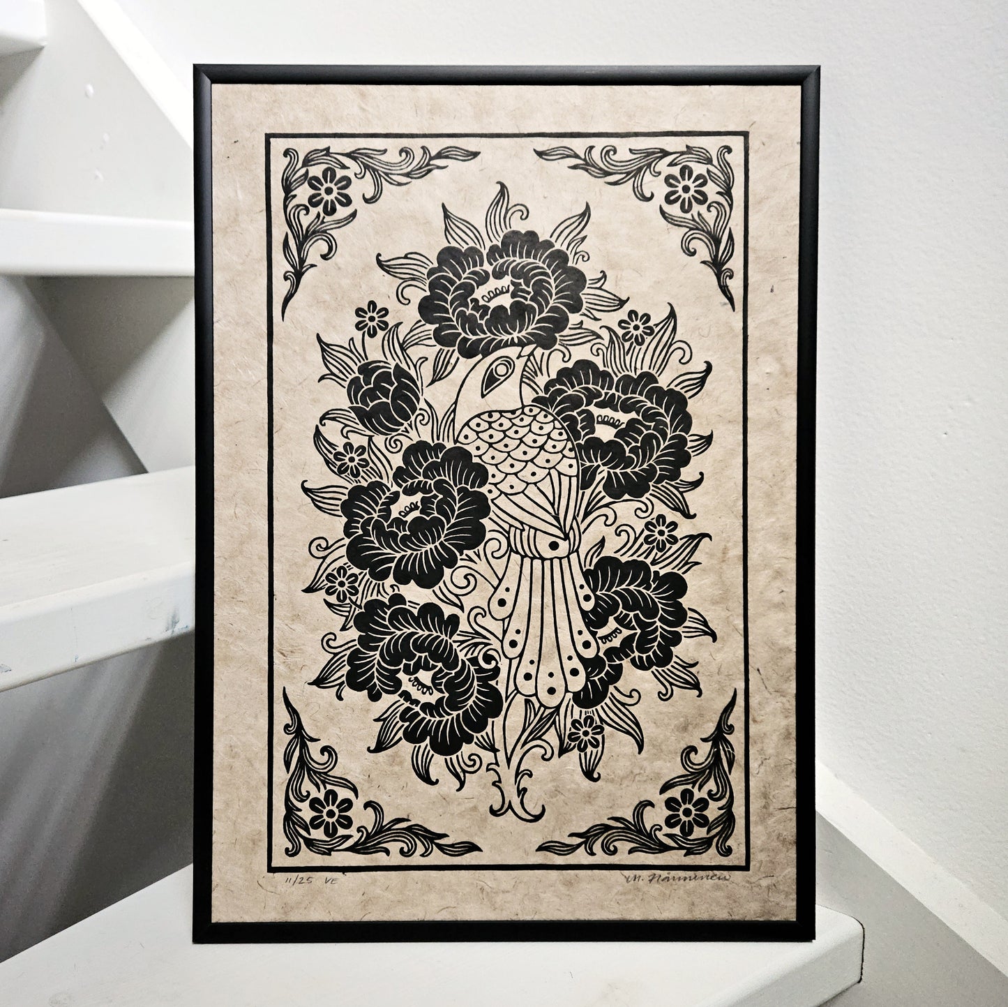 Framed linocut print of a bird and peony flowers printed in black on unbleached paper