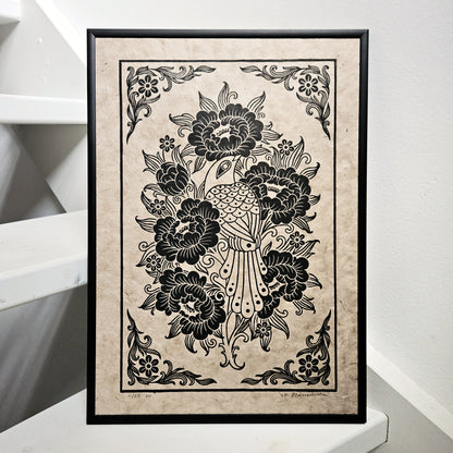 Framed linocut print of a bird and peony flowers printed in black on unbleached paper