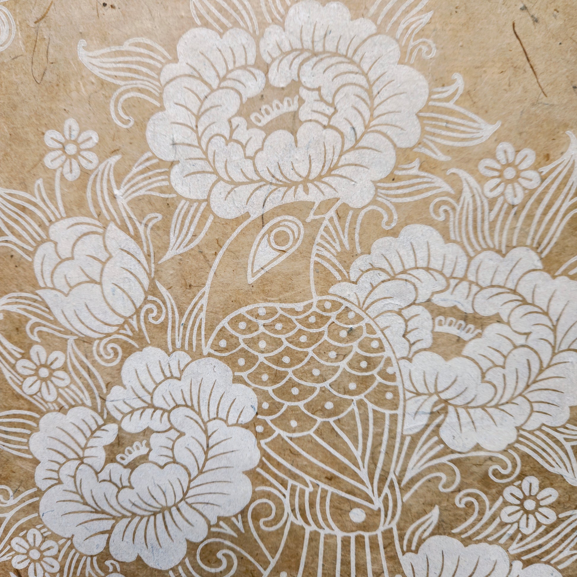 Detail of a white floral linocut print on unbleached paper