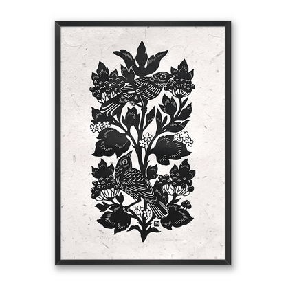 A relief print of song birds in a flowering berry bush in a thin black frame