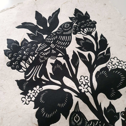 Detail of a handmade art print with a bird in a berry bush