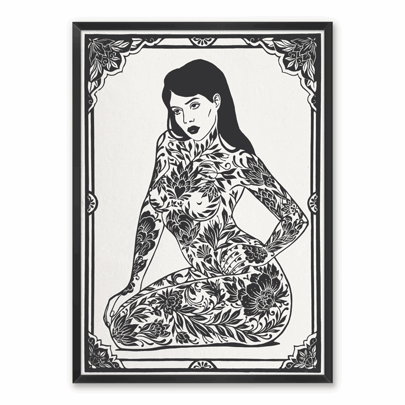 A black and white linocut print of a tattooed woman, framed on a wall