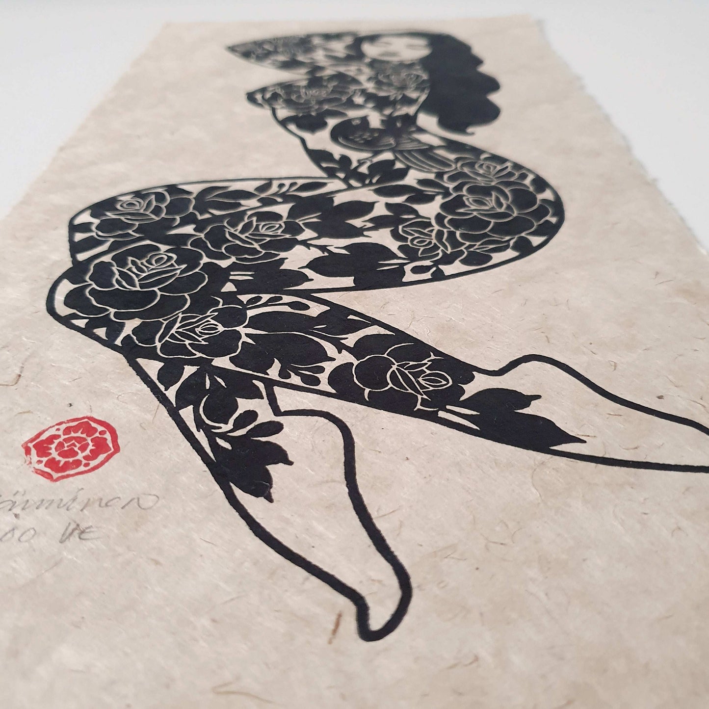 Sideview of a linocut block print with a tattooed lady