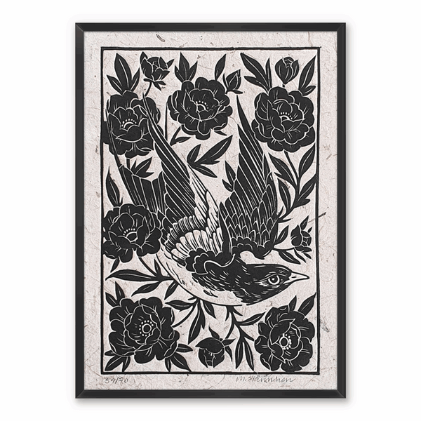 A framed linocut print of a swallow flying through flowers