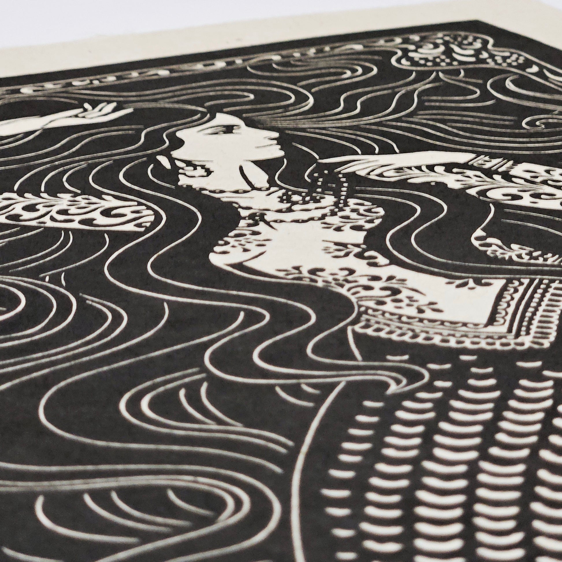 Black and white illustration of a mermaid with flowing hair and patterns in the background